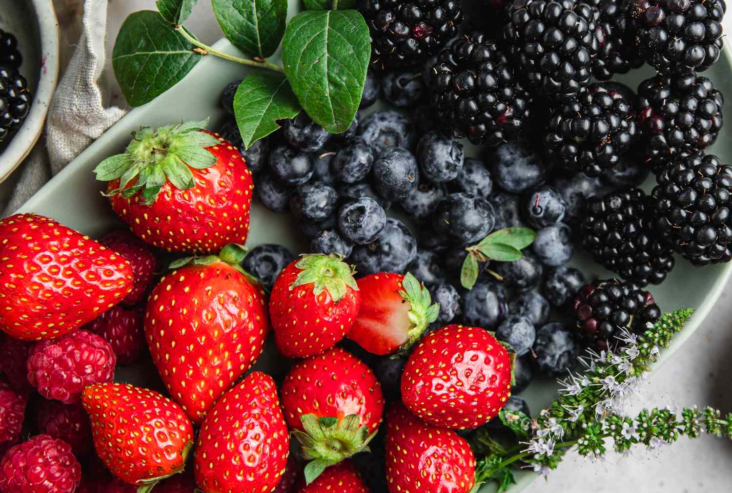 A plate with fresh strawberries raspberries blueberries and blackberries