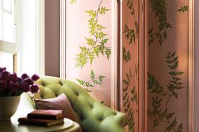 A pink room divider with green pressed leaves.