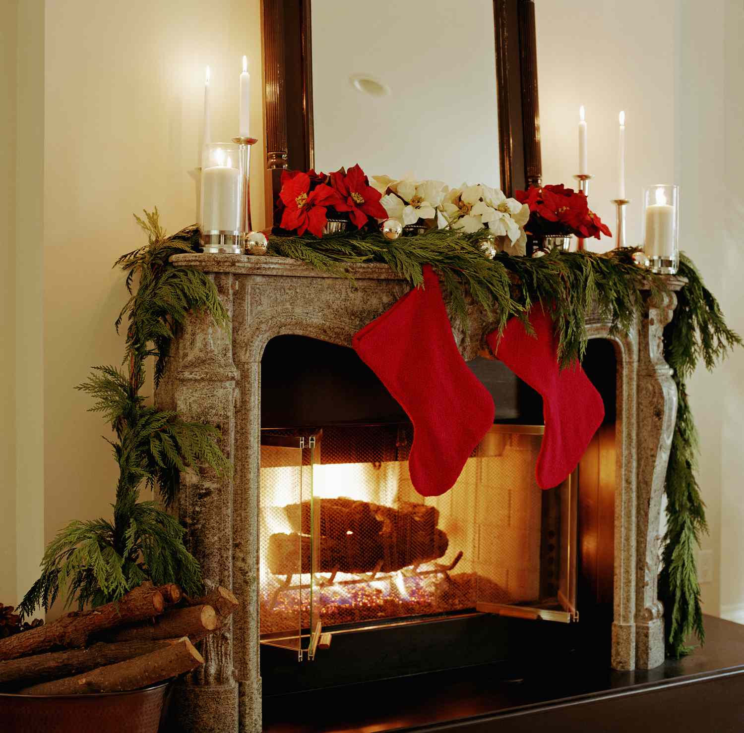 A festive decorated fireplace with stockings and holiday greenery