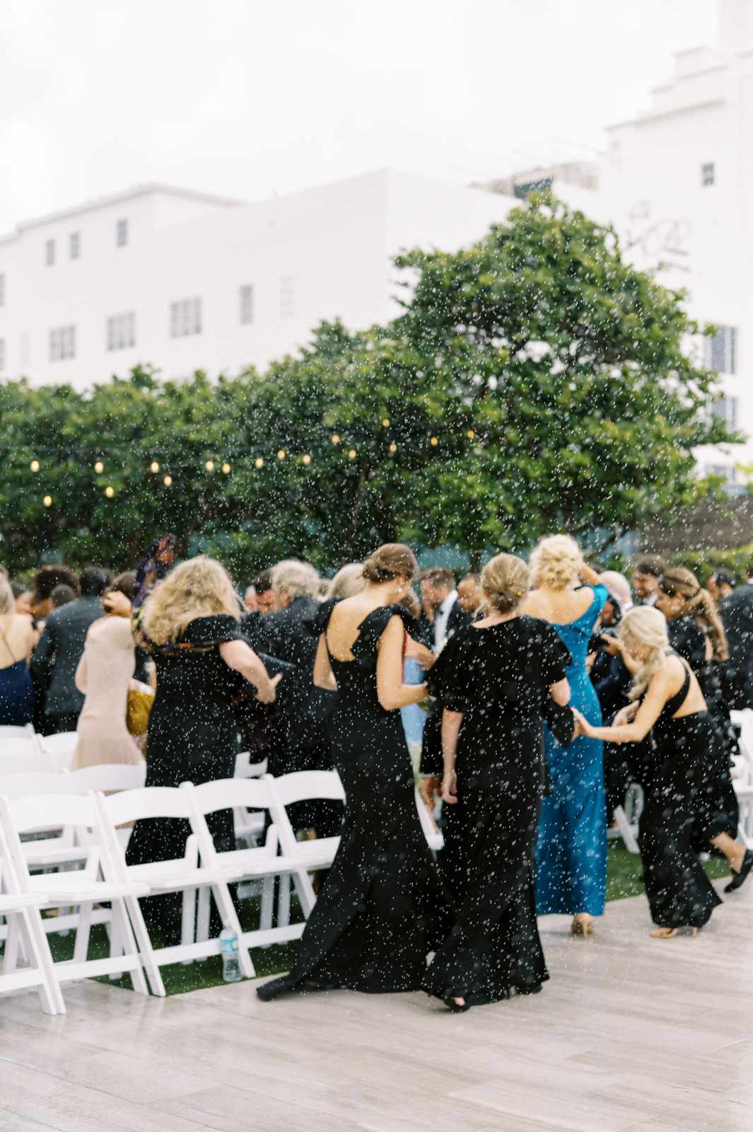 guests and wedding party walking inside during rain