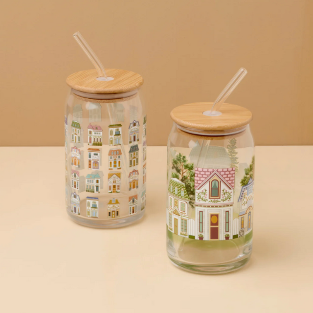 Two glass tumblers with house designs featuring bamboo lids and clear straws