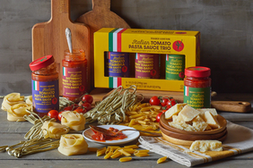 An assortment of Italian pasta sauces and ingredients including jars of sauce various pasta types cheese and tomatoes