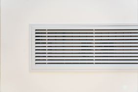 A rectangular air vent with horizontal slats on a wall