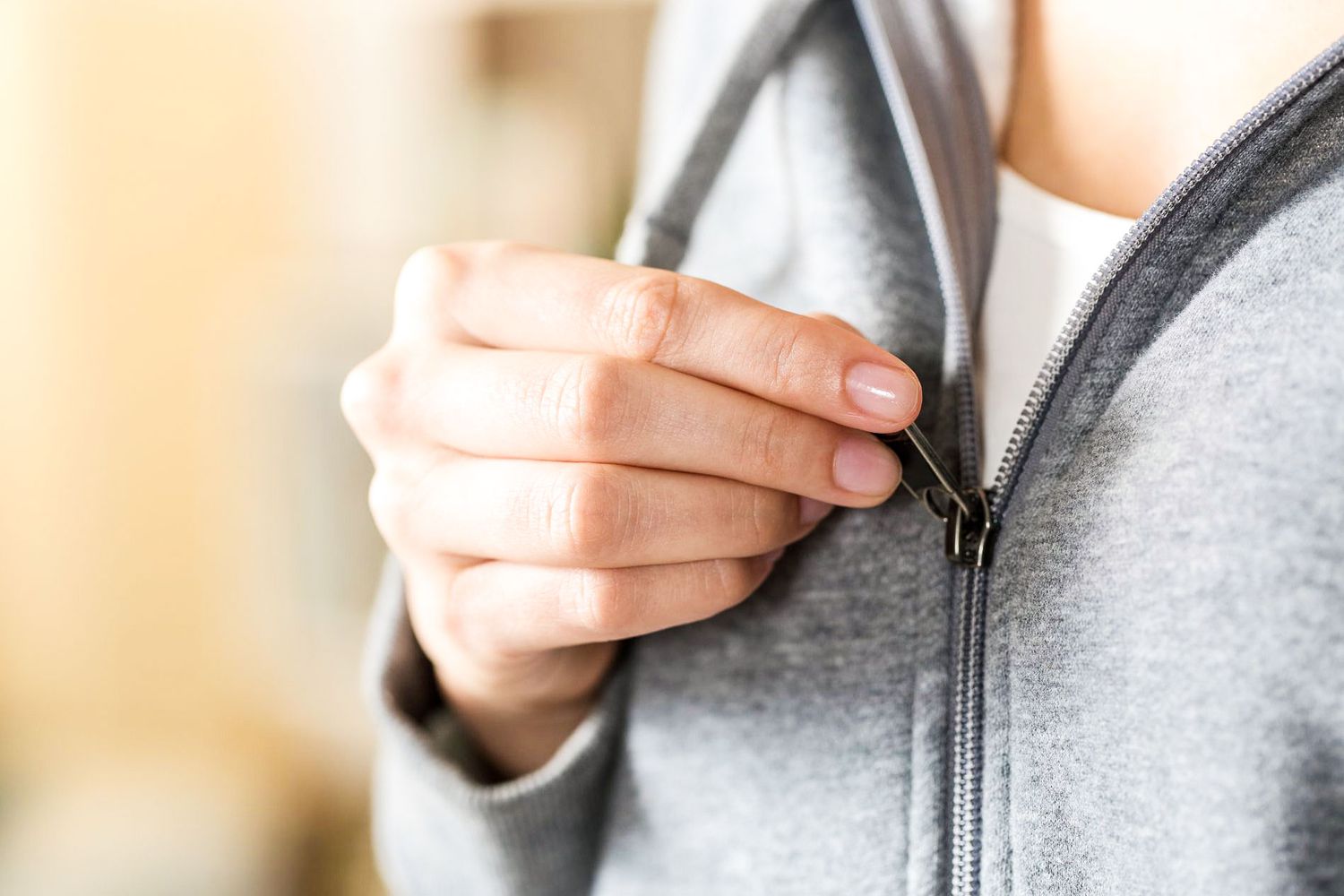 zipping up grey sweatshirt