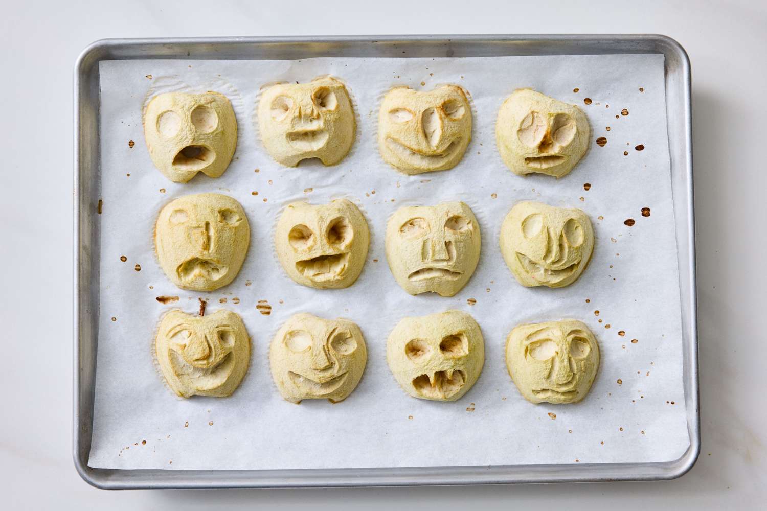 Baked goods shaped as faces on a tray