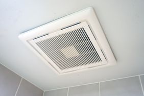 A ceilingmounted ventilation fan in a tiled bathroom