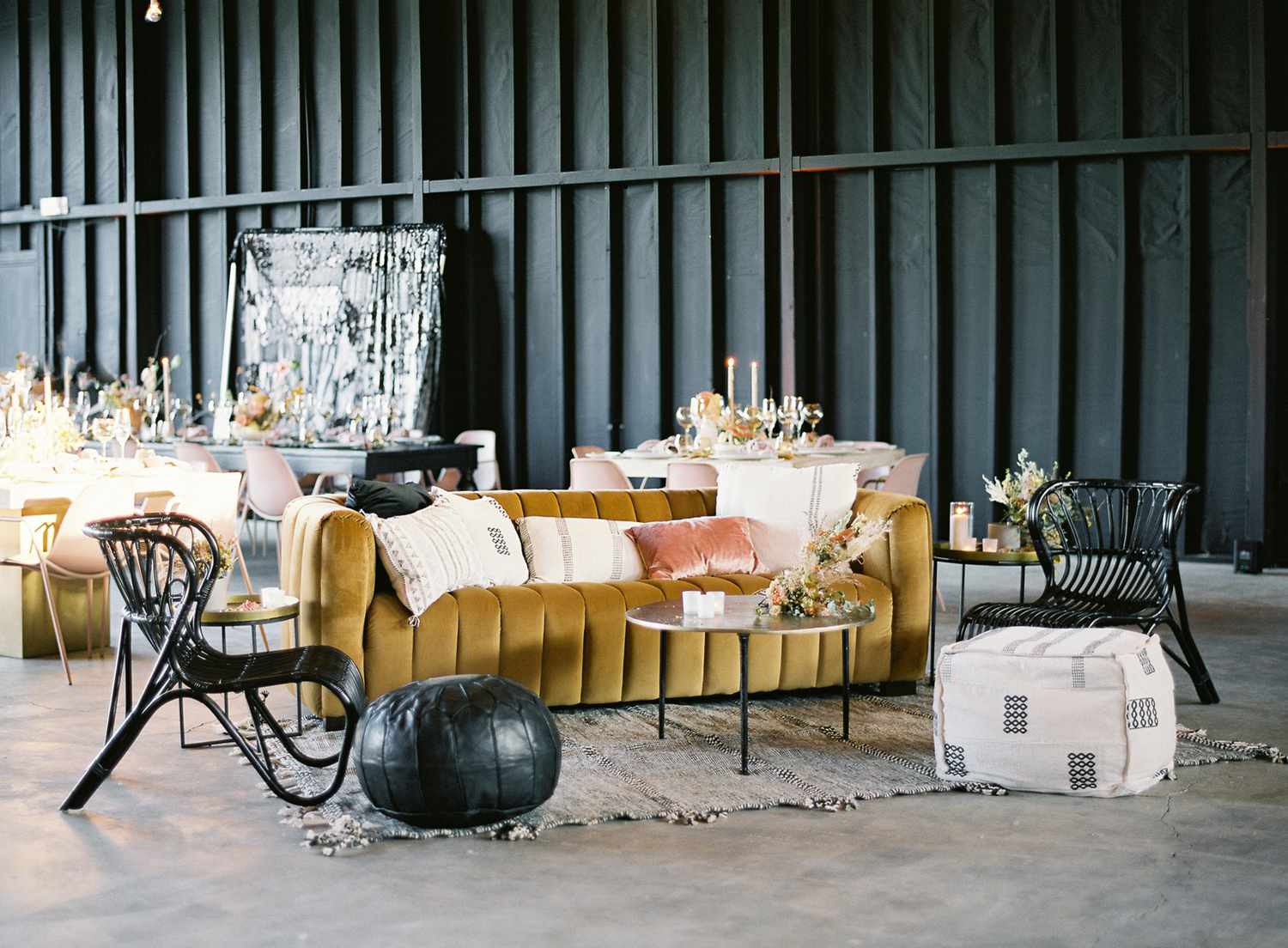 lounge space with bold colored couches and black wicker chairs