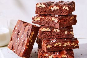 fudgy turtle brownies stacked on cutting board