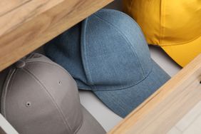 Stylish baseball caps in chest of drawers, closeup. Mockup for design