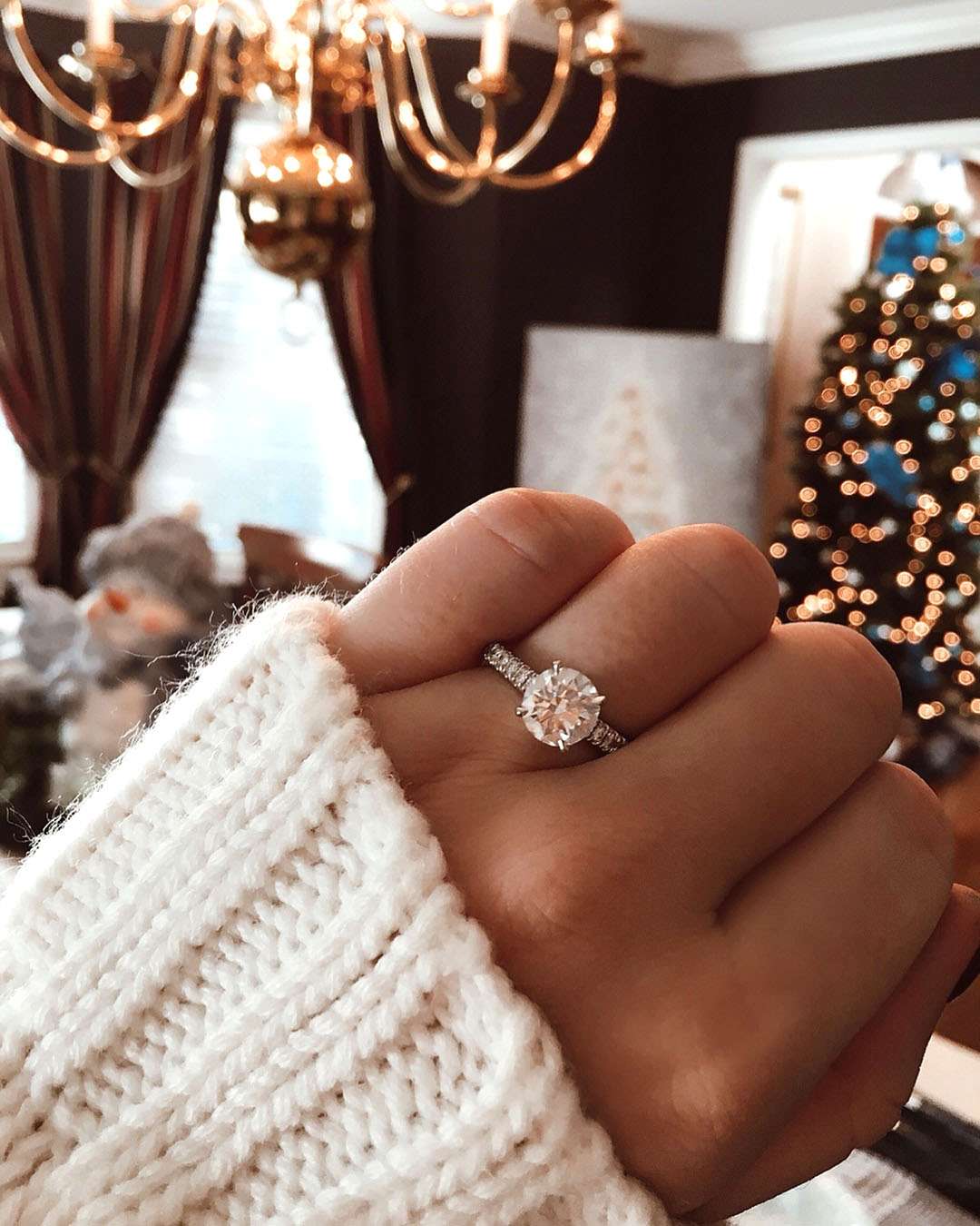 engagement ring selfie in front of christmas tree