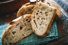Sliced artisan bread placed on a greenstriped cloth