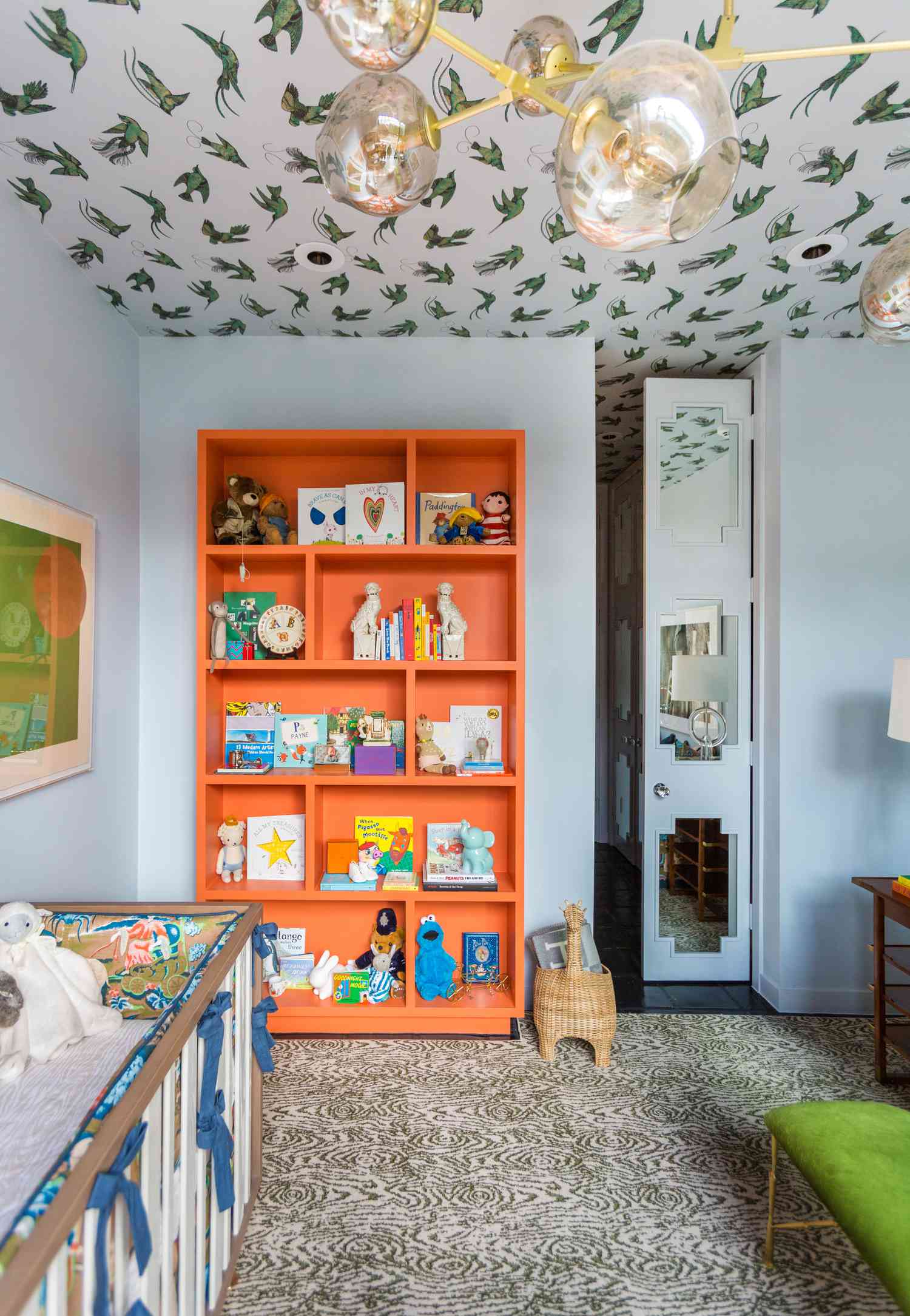 kid's room with blue walls and orange bookcase