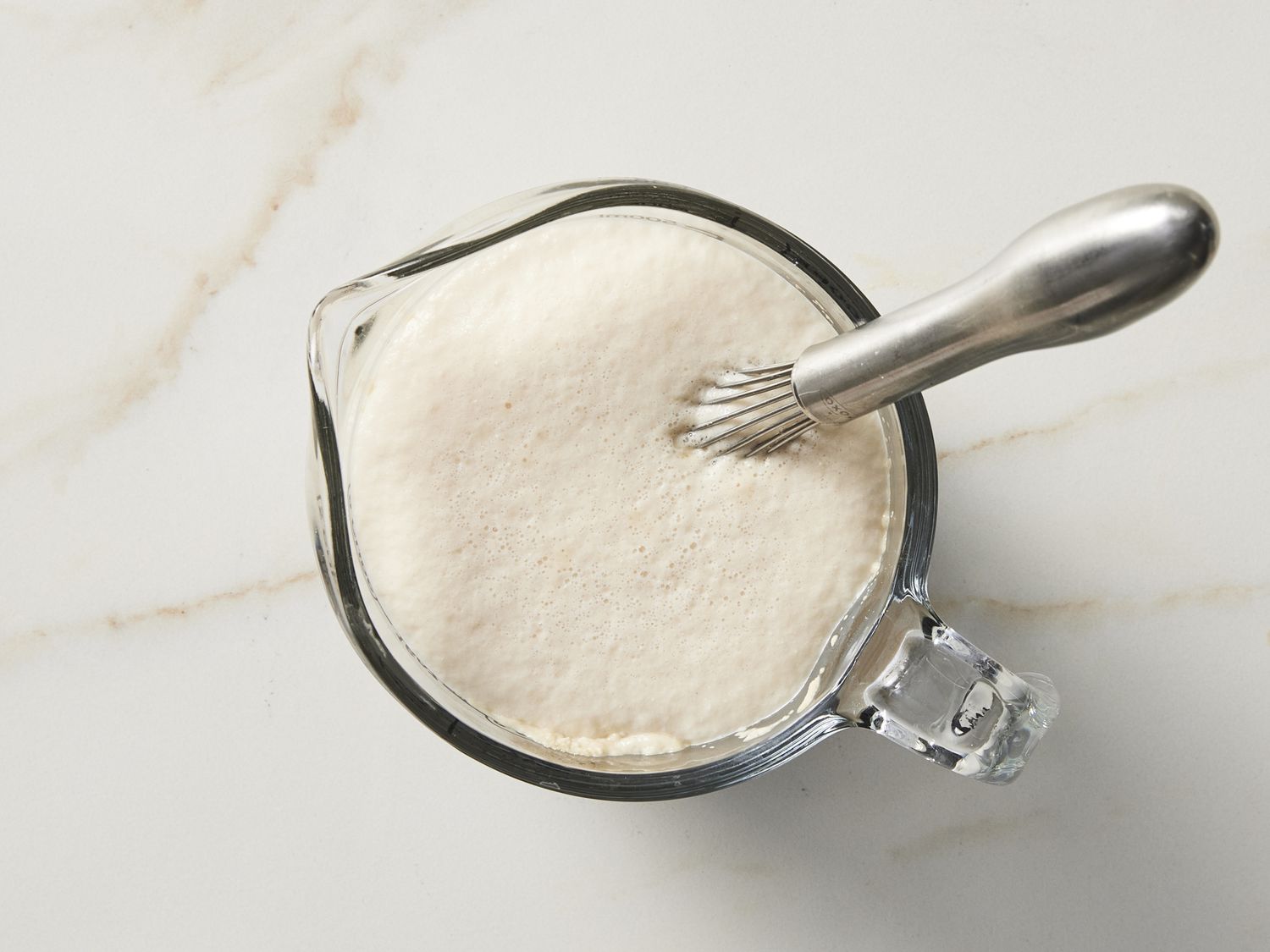 Yeast rising in bowl with whisk