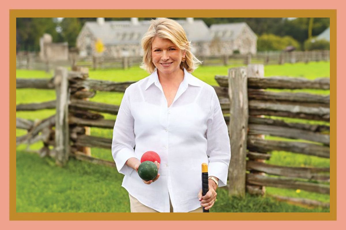 decorvow holding a ball and stick outdoors by a wooden fence