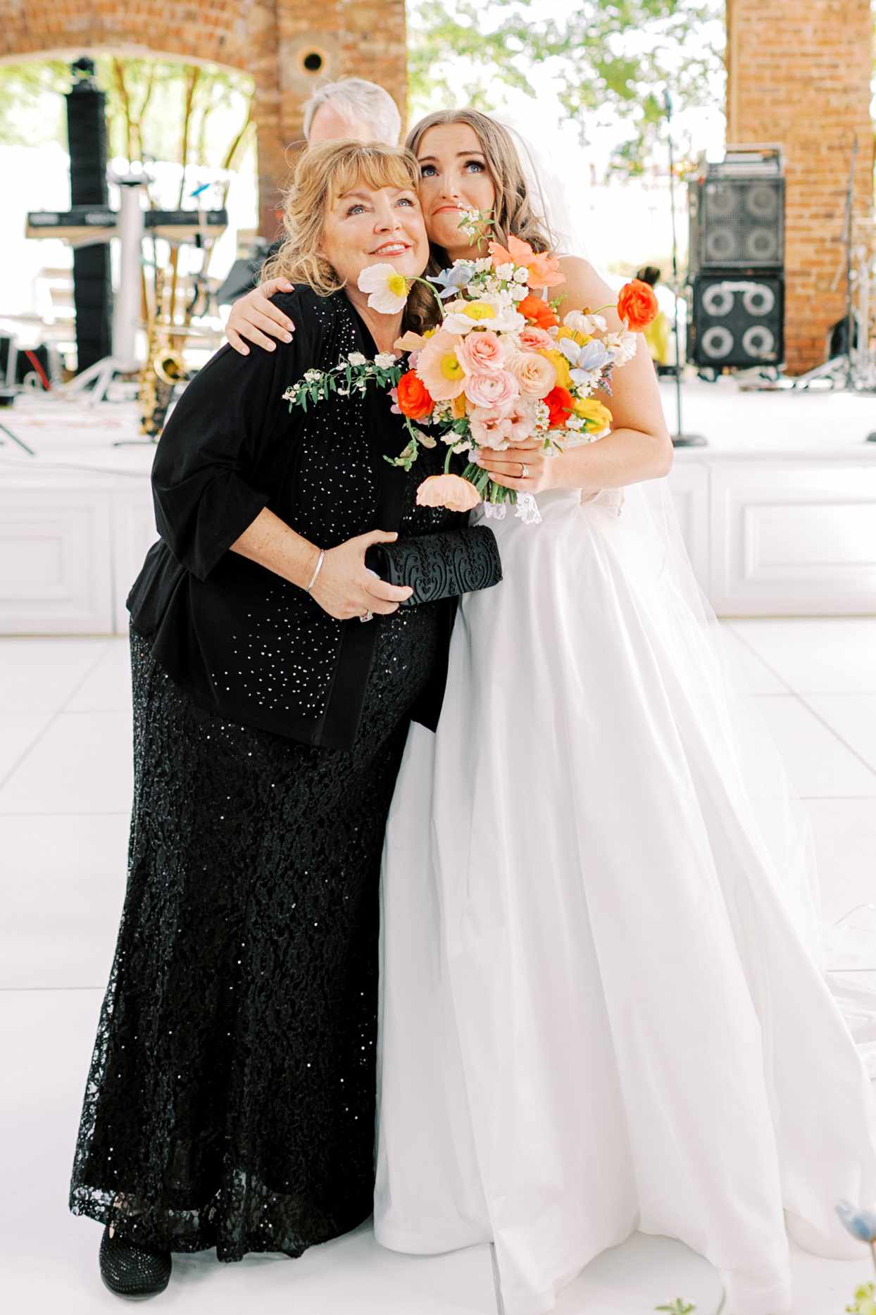 mother of the bride hugging bride during wedding reception
