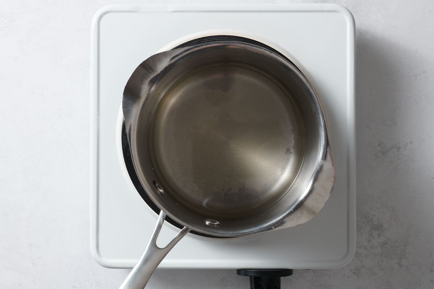 making sugar syrup in small pan over heat