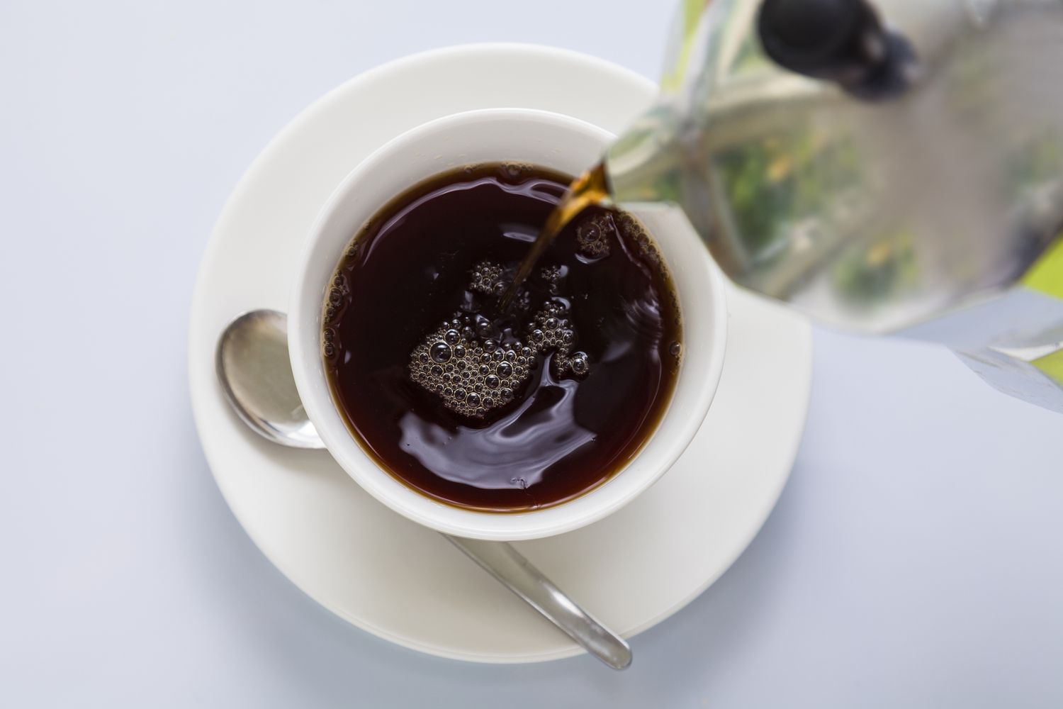 Black coffee being poured from coffee pot