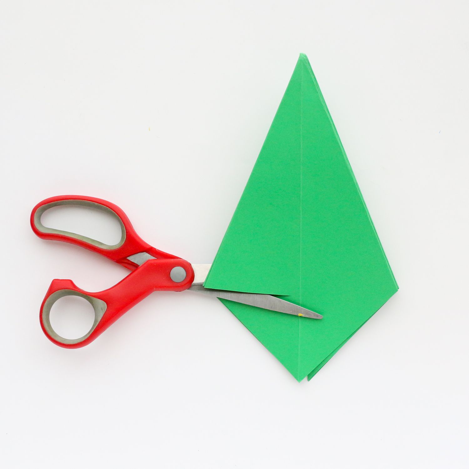 Green piece of folded paper being cut. 