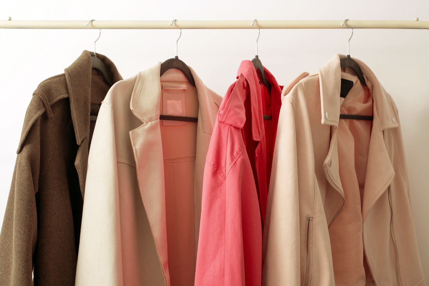 Assorted coats hanging on hangers on a clothing rack