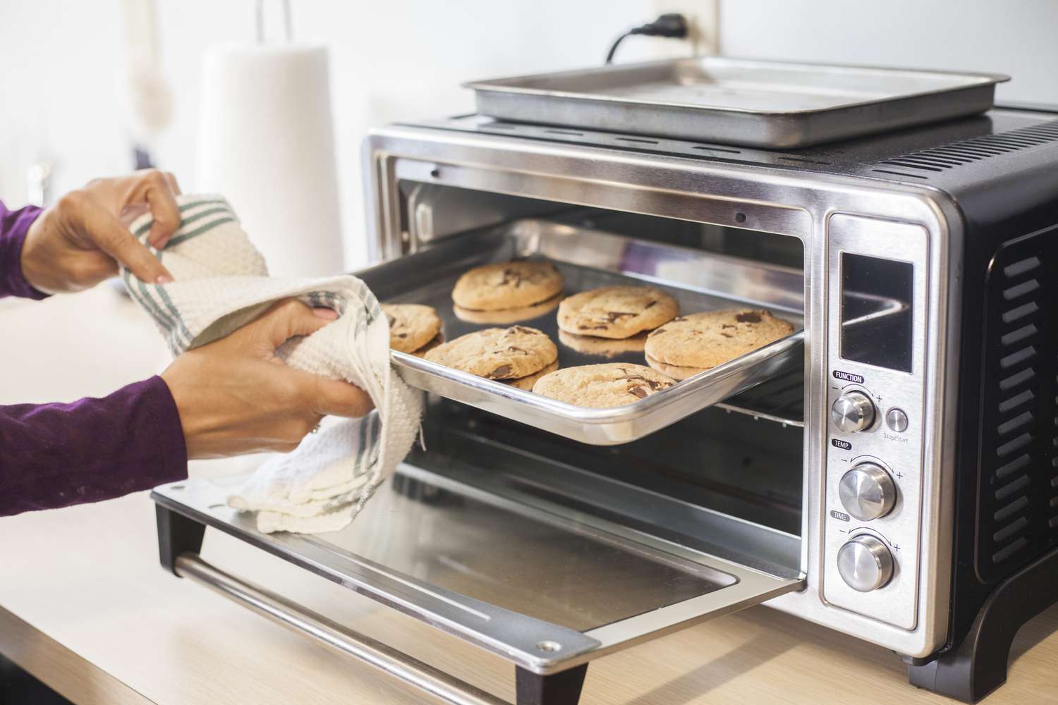chocolate chip cookies baking in a silver toaster oven