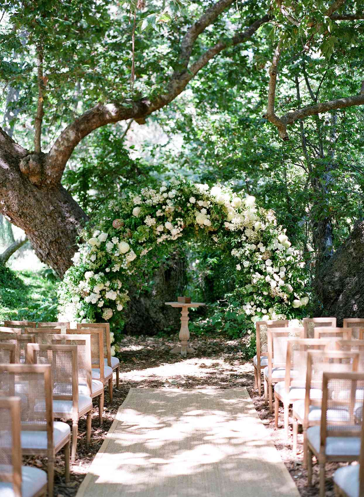 large white floral wedding arch for outdoor wedding ceremony