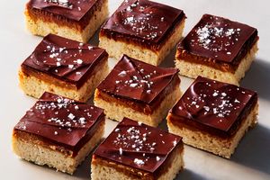 Chocolatetopped caramel cookie bars with a sprinkle of sea salt arranged in a grid format