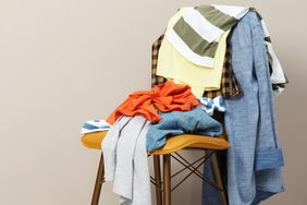 A chair with various clothes draped and piled upon it