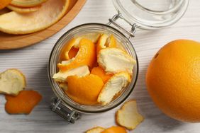 orange peels in glass jar on white wood surface