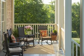 A porch with seating and decorative elements overlooking a green landscape