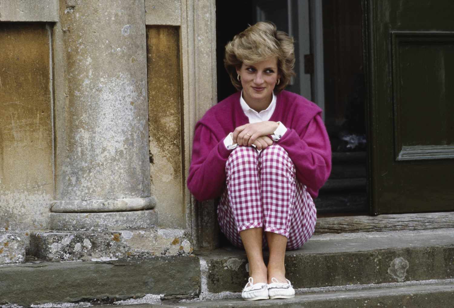 Princess Diana sitting on the outside steps of her home