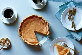 classic pumpkin pie on blue table with coffee