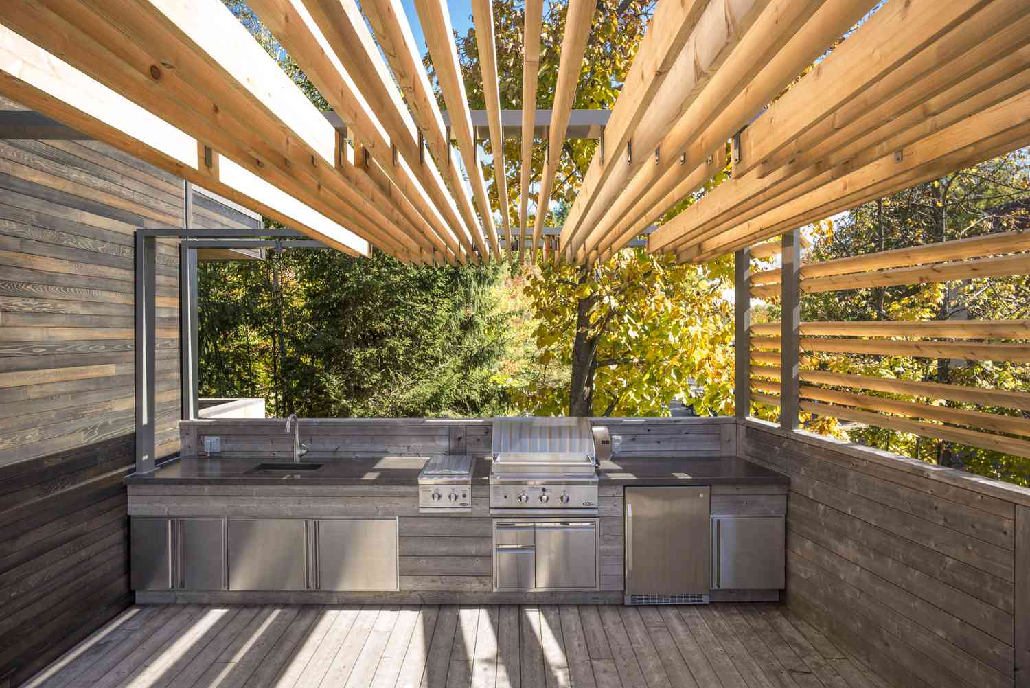an outdoor kitchen designed with wooden slats