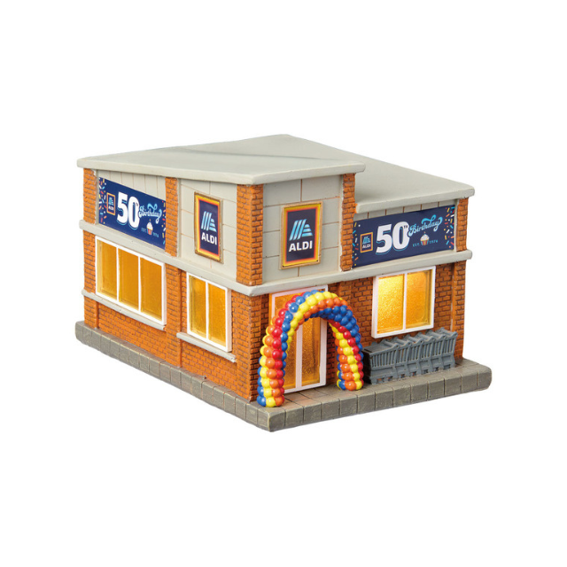 A model of an Aldi store showcasing a 50th anniversary celebration with a balloon arch at the entrance