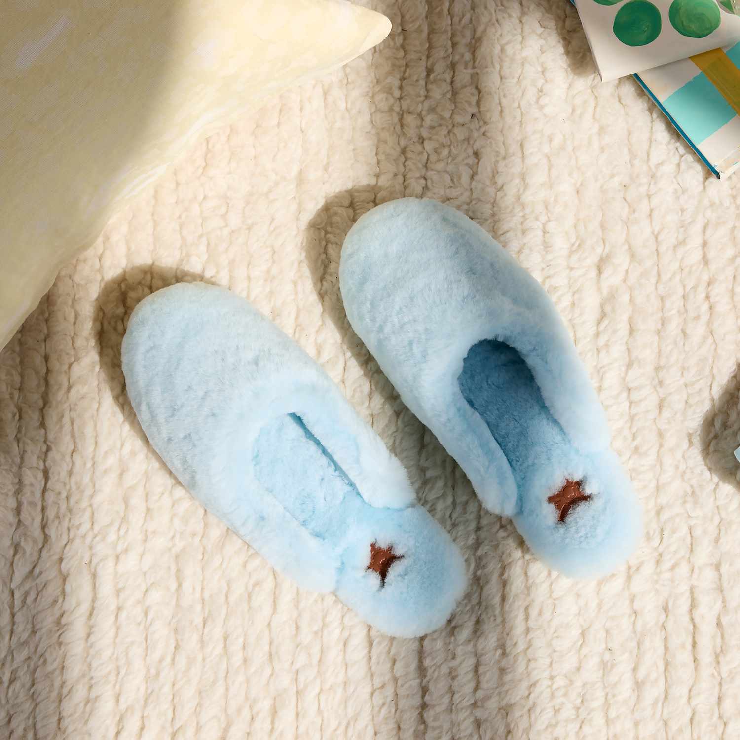 blue shearling slippers on a rug