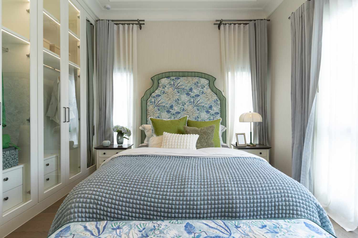 Wellorganized bedroom with a bed decorative pillows and curtains emphasizing interior design