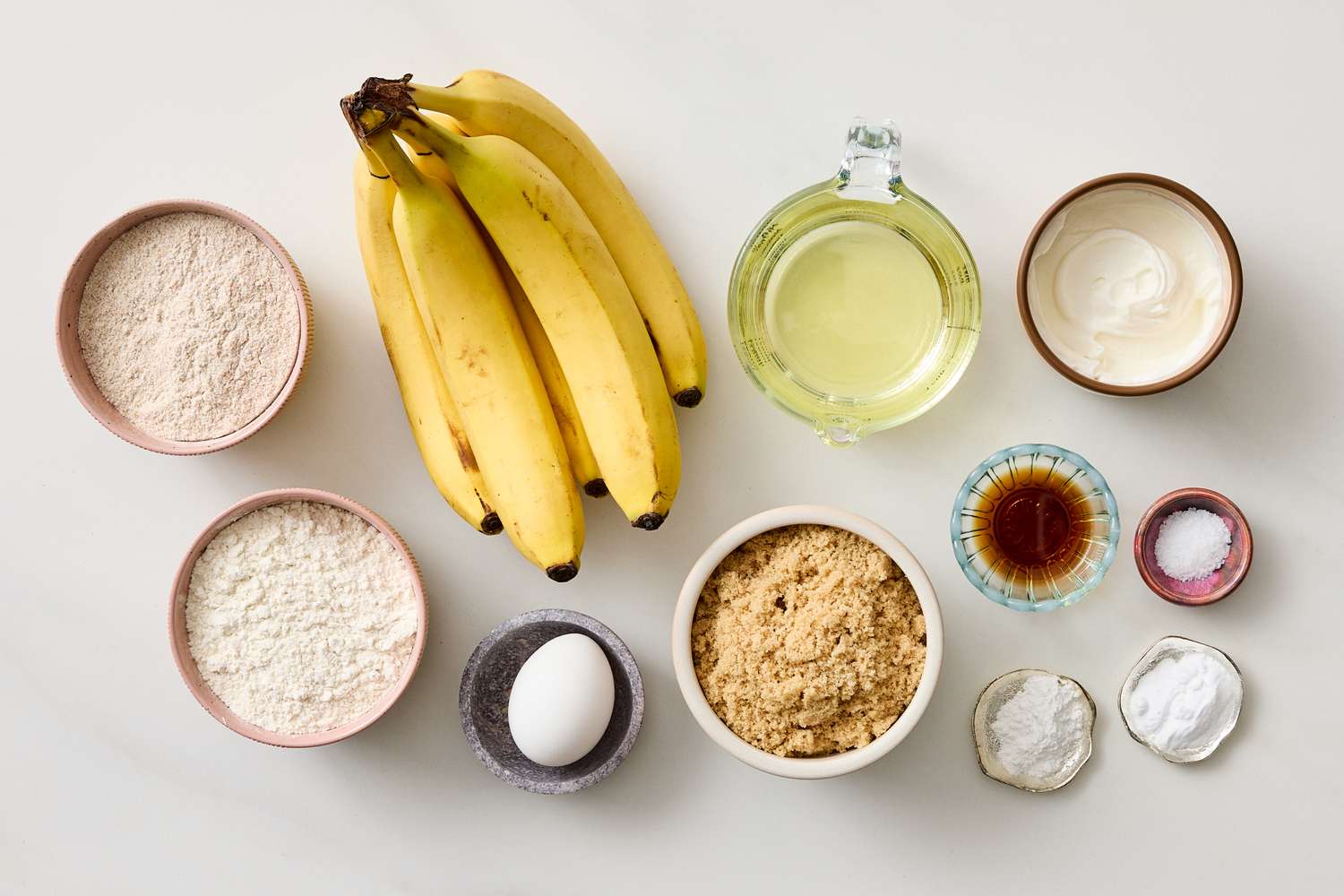 Ingredients for making banana muffins including bananas flour sugar egg yogurt oil and baking powder