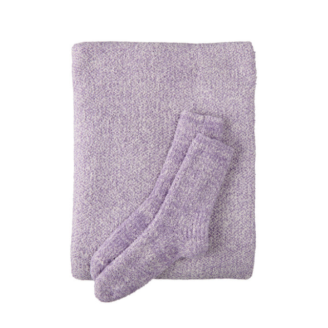 A textured blanket and a pair of socks folded together