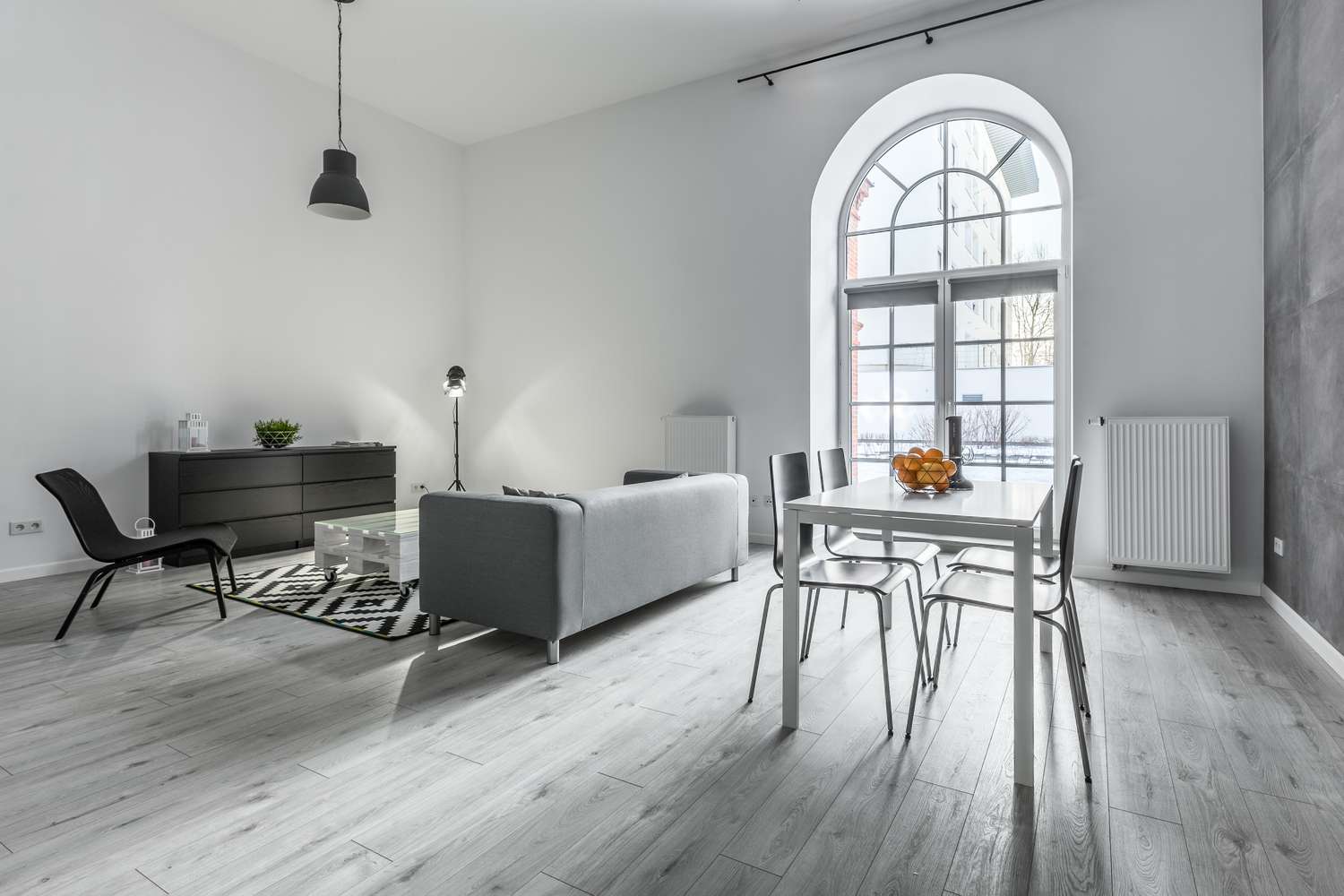 Modern living space with a sofa dining table and large arched window