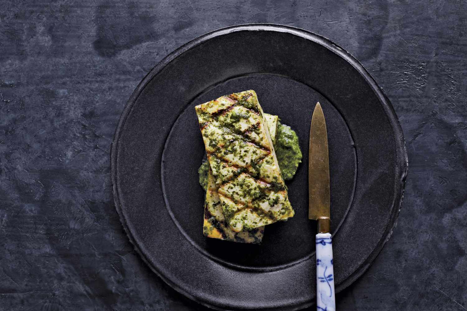tofu with ginger cilantro sauce served on a black plate