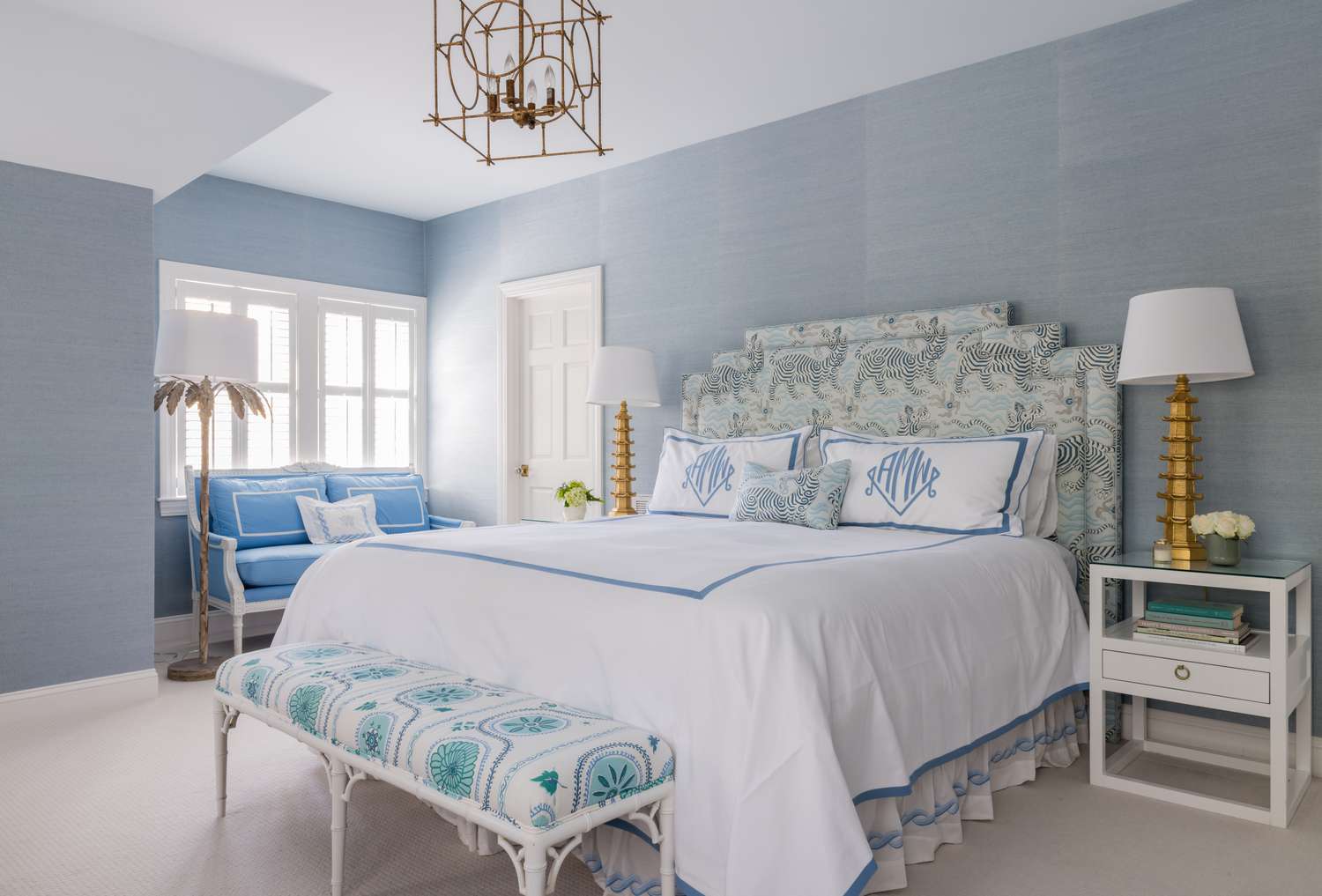 a blue bedroom with brass lighting