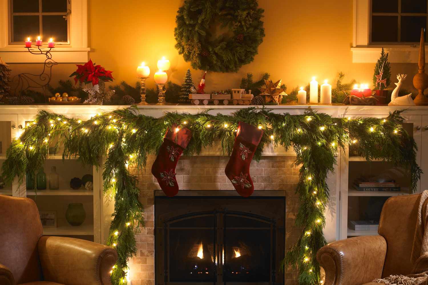 Christmas decorated fireplace with garlands stockings candles and lights