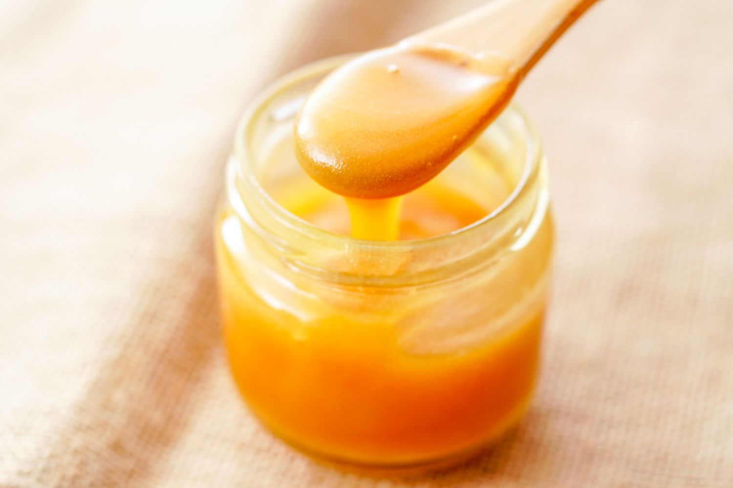 manuka honey in glass jar with wooden spoon