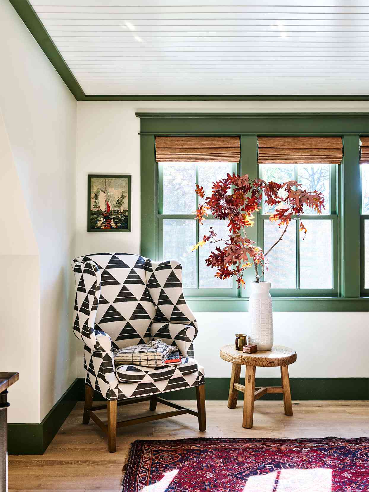 wing chair in front of green-trim window