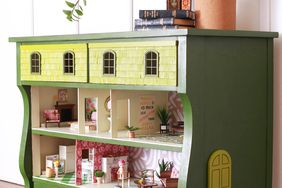 green dresser with dollhouse inside