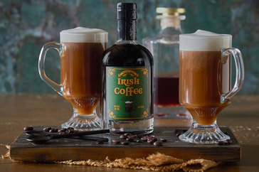 Irish coffee bottle with two mugs of coffee on a wooden tray
