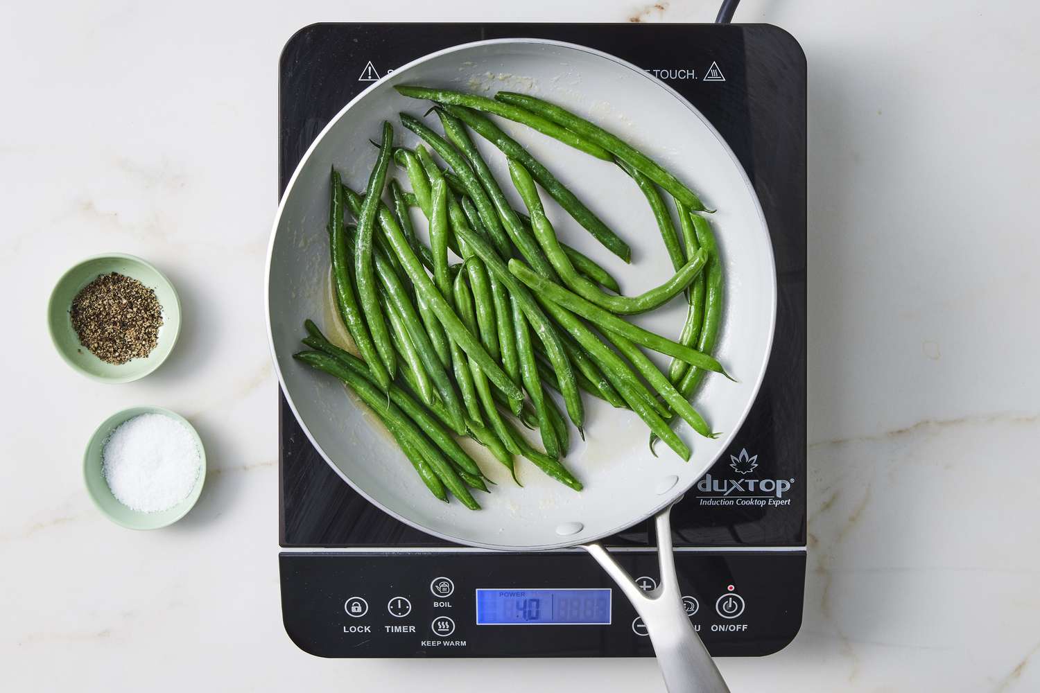 green beans in pan with salt and pepper