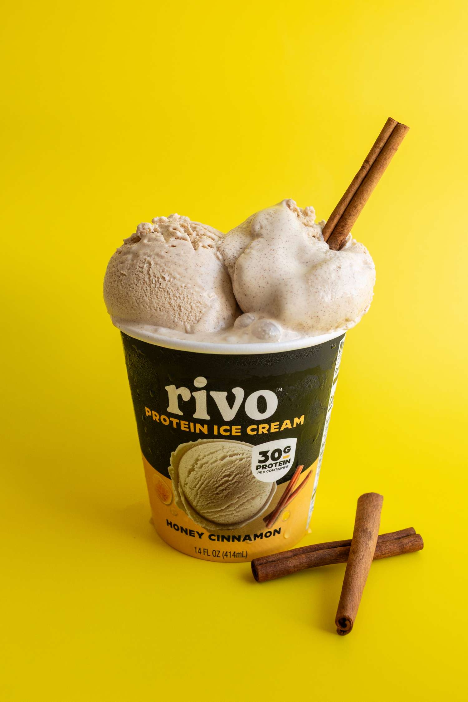 rivo high protein ice cream in carton with lid off and cinnamon stick 