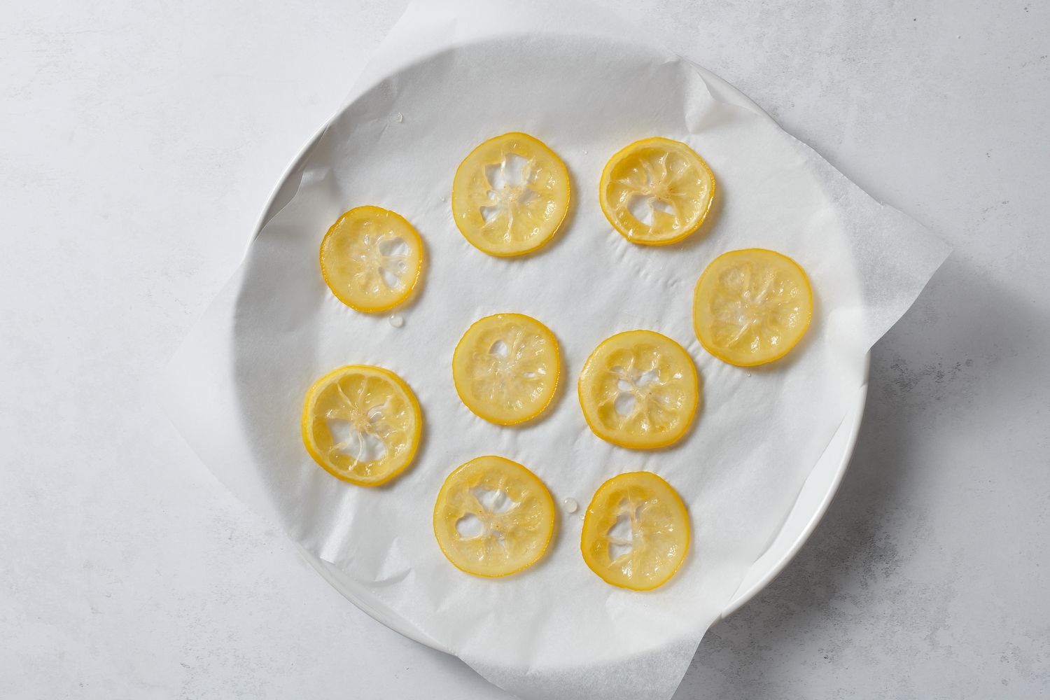 candied lemon slices on parchment paper on plate