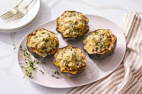 Acorn squash halves filled with rice and herbs arranged on a plate