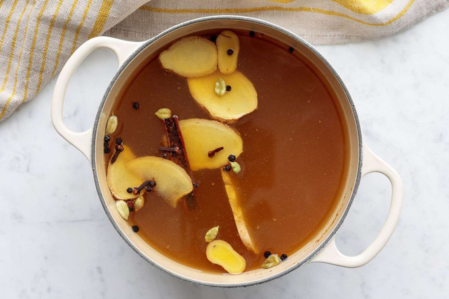 overhead of pot of chai apple cider on marble surface